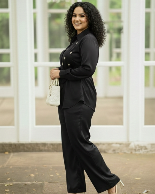 Woman in a black suit standing in front of a white window structure.