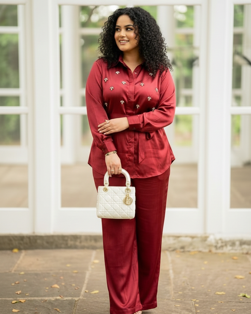 Woman in a red outfit holding a white handbag in front of a white lattice background